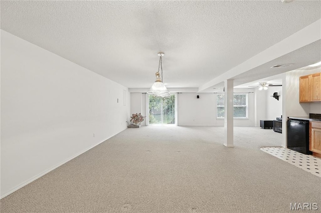 1516 Lienemann Dr Unit 26, Saint Charles, MO 63303 - unfurnished living room featuring light colored carpet, healthy amount of natural light, a ceiling fan, and a textured ceiling