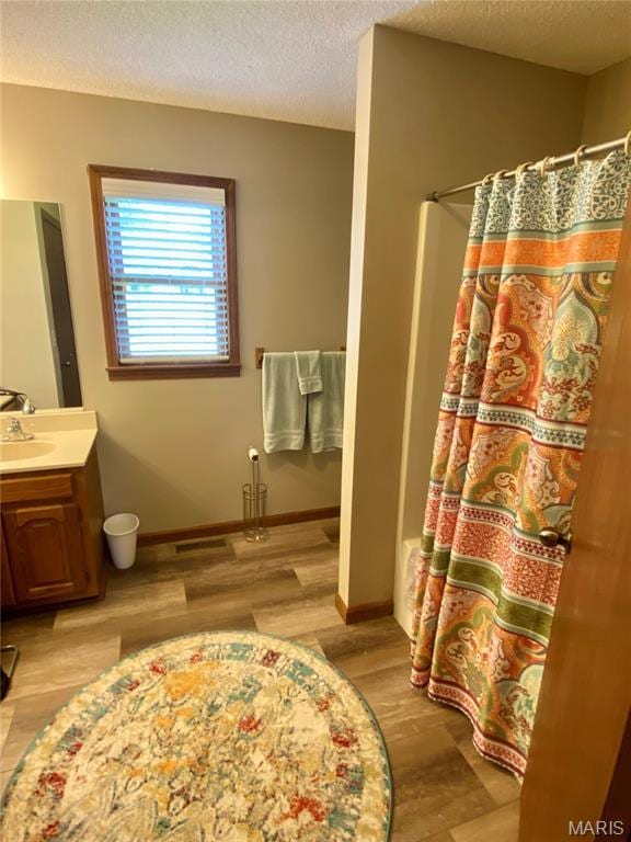 840 Delta Pine Ln, Sikeston, MO 63801 - full bath featuring vanity, wood finished floors, a textured ceiling, and curtained shower