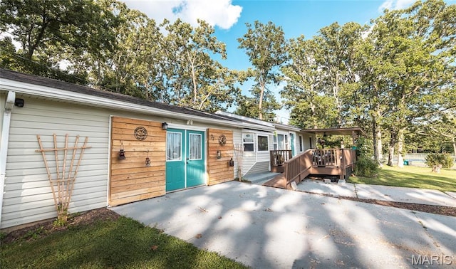 77 Indian Hills Dr, Cuba, MO 65453 - back of property with a deck, a patio area, and a lawn