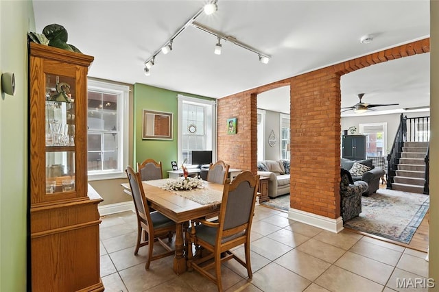 2812 Indiana Ave, Saint Louis, MO 63118 - dining space with brick wall, light tile patterned floors, a ceiling fan, and stairway