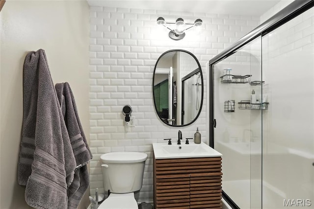 2812 Indiana Ave, Saint Louis, MO 63118 - bathroom featuring a shower with shower door, vanity, and tile walls