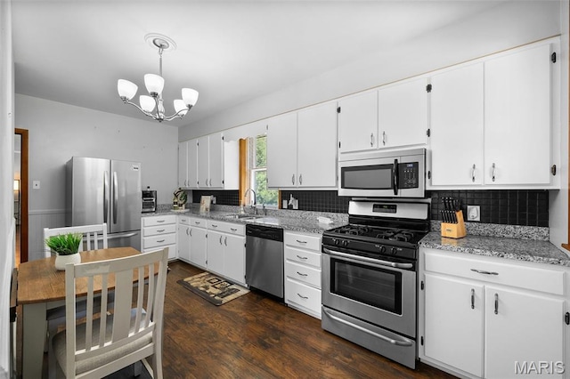 512 N Hills Dr, Saint Louis, MO 63121 - kitchen with stainless steel appliances, a chandelier, white cabinets, and dark wood finished floors