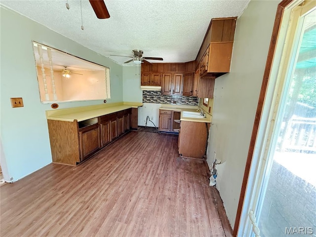 335 Sumac St, Payson, IL 62360 - kitchen with ceiling fan, brown cabinets, wood finished floors, light countertops, and tasteful backsplash