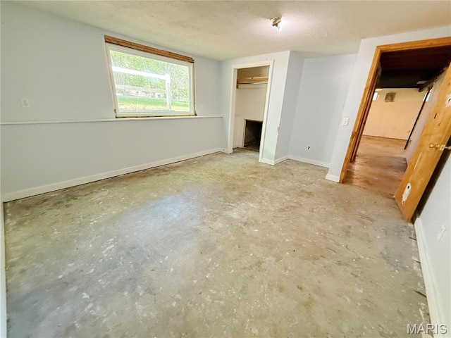 335 Sumac St, Payson, IL 62360 - unfurnished bedroom with unfinished concrete floors, a textured ceiling, and a closet
