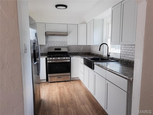 119 Freedom Dr, Belleville, IL 62226 - kitchen with stainless steel appliances, decorative backsplash, light wood-style flooring, dark countertops, and a textured wall