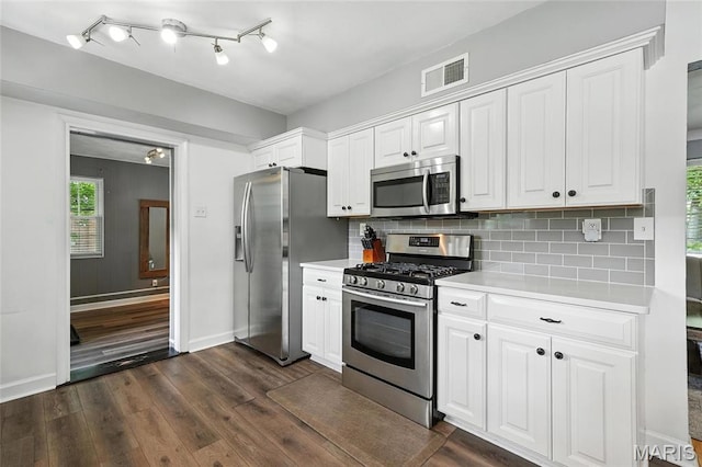 7616 Suffolk Ave, Saint Louis, MO 63119 - kitchen featuring appliances with stainless steel finishes, light countertops, dark wood-style floors, and white cabinetry