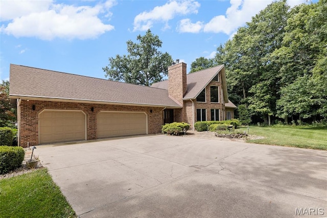 4775 S Hazel Rd, Edwardsville, IL 62025 - view of front of home featuring driveway, a garage, brick siding, and a chimney