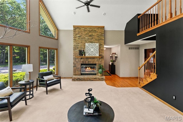 4775 S Hazel Rd, Edwardsville, IL 62025 - living room with high vaulted ceiling, ceiling fan, carpet, a brick fireplace, and stairway