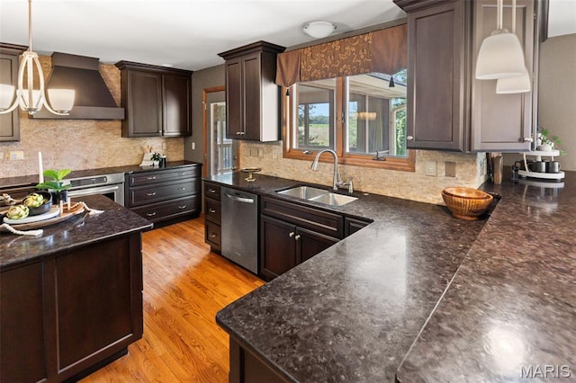 4775 S Hazel Rd, Edwardsville, IL 62025 - kitchen with range hood, stainless steel appliances, dark brown cabinetry, decorative backsplash, and pendant lighting
