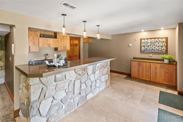 4775 S Hazel Rd, Edwardsville, IL 62025 - kitchen with dark countertops, a peninsula, hanging light fixtures, light tile patterned flooring, and recessed lighting