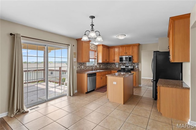 672 Berrywine Ln, Arnold, MO 63010 - kitchen featuring appliances with stainless steel finishes, a center island, decorative backsplash, light tile patterned floors, and stone countertops