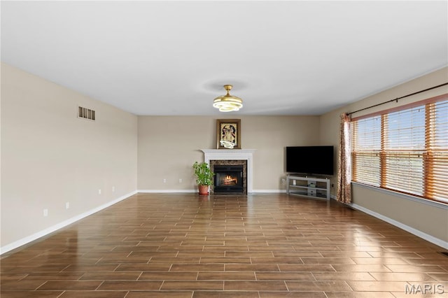 672 Berrywine Ln, Arnold, MO 63010 - unfurnished living room with a warm lit fireplace and dark wood-style flooring