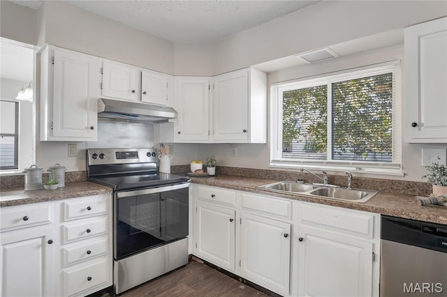 8219 Pear Ln, Saint Louis, MO 63123 - kitchen with stainless steel appliances, under cabinet range hood, white cabinetry, and dark wood finished floors