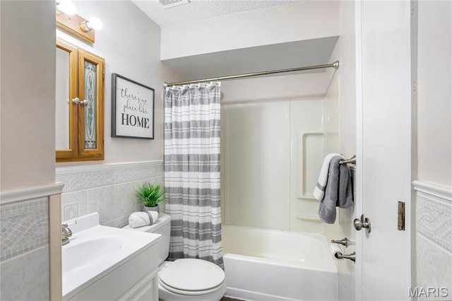 8219 Pear Ln, Saint Louis, MO 63123 - full bathroom featuring tile walls, vanity, shower / tub combo, a wainscoted wall, and a textured ceiling