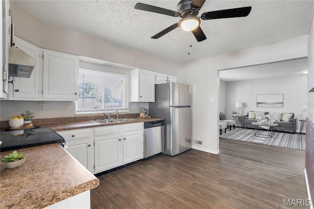 8219 Pear Ln, Saint Louis, MO 63123 - kitchen featuring appliances with stainless steel finishes, ventilation hood, dark wood-type flooring, white cabinets, and a textured ceiling