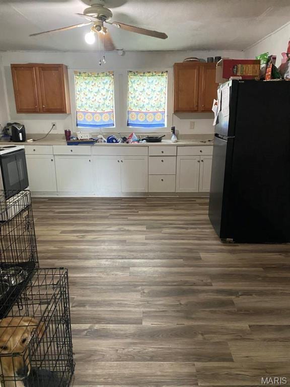 823 W Washington St, St James, MO 65559 - kitchen featuring freestanding refrigerator, a ceiling fan, wood finished floors, light countertops, and white cabinets