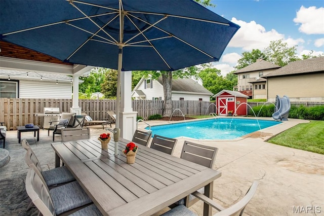 1029 Brownell Ave, Glendale, MO 63122 - view of swimming pool with a patio, outdoor dining space, a water slide, a storage shed, and a fenced backyard