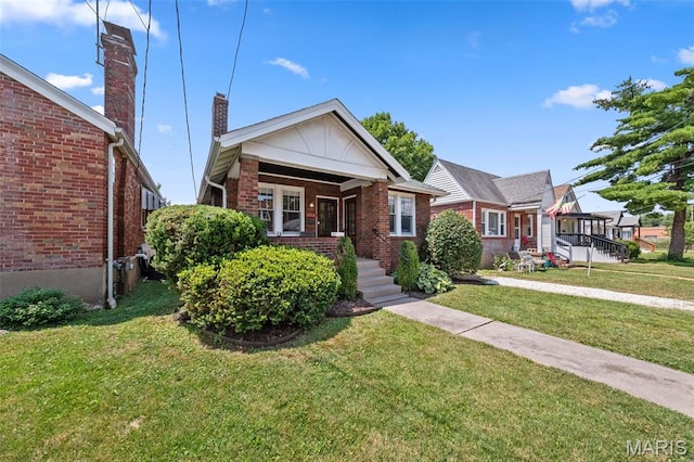 6016 Scanlan Ave, Saint Louis, MO 63139 - bungalow featuring brick siding, a front lawn, a chimney, and a porch