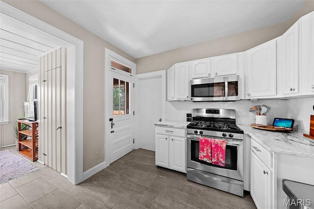 6016 Scanlan Ave, Saint Louis, MO 63139 - kitchen featuring appliances with stainless steel finishes, white cabinetry, light stone counters, and tasteful backsplash