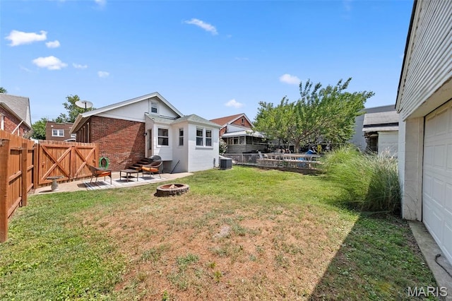 6016 Scanlan Ave, Saint Louis, MO 63139 - fenced backyard with an outdoor fire pit, a gate, a garage, and a patio area