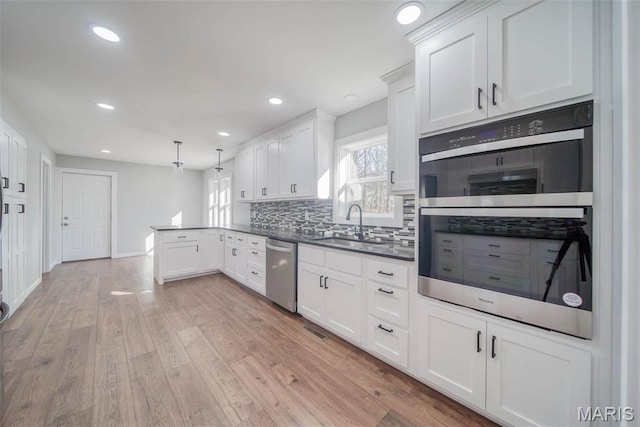 11880 County Road 3040, Rolla, MO 65401 - kitchen featuring appliances with stainless steel finishes, a peninsula, white cabinets, tasteful backsplash, and dark countertops