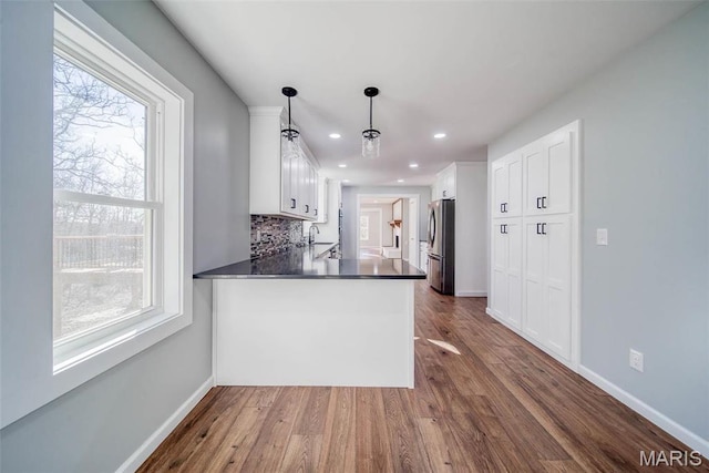 11880 County Road 3040, Rolla, MO 65401 - kitchen with freestanding refrigerator, dark countertops, white cabinets, a peninsula, and backsplash