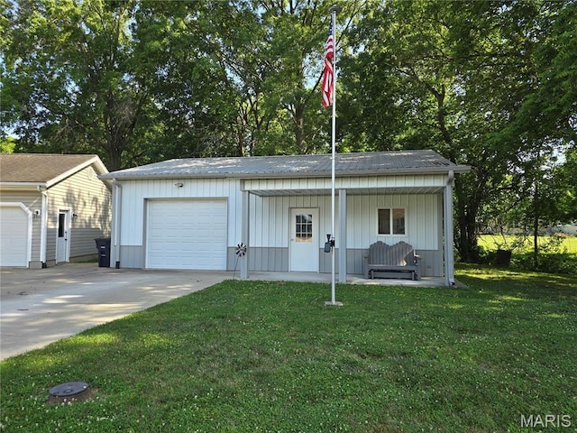 310 E 1st St, Ramsey, IL 62080 - view of front facade featuring a front yard, concrete driveway, board and batten siding, and an outbuilding