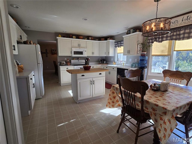310 E 1st St, Ramsey, IL 62080 - kitchen with white appliances, a center island, and white cabinetry