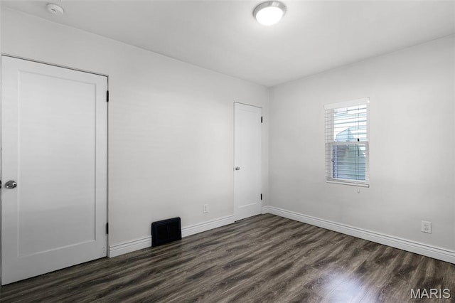7104 Leona St, Saint Louis, MO 63116 - unfurnished bedroom with dark wood-style flooring and baseboards