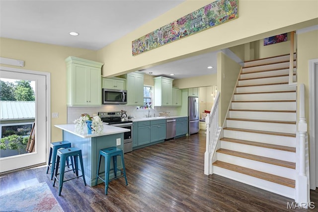 4846 S Point Rd, Washington, MO 63090 - kitchen with stainless steel appliances, a peninsula, green cabinetry, light countertops, and plenty of natural light