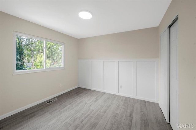 383 Messina Dr, Ballwin, MO 63021 - spare room featuring a decorative wall, wood finished floors, and a wainscoted wall