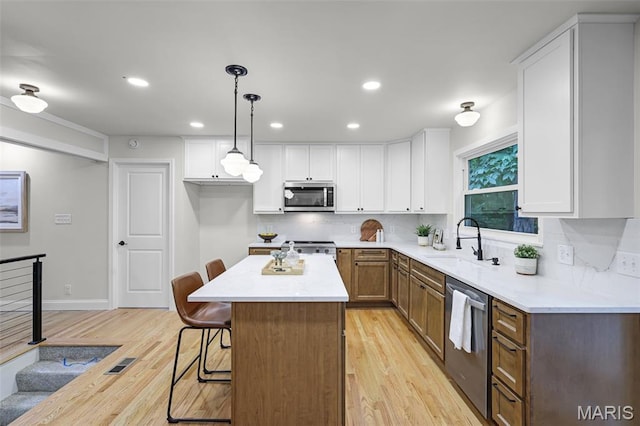 246 Leichester Cir, Ballwin, MO 63011 - kitchen with appliances with stainless steel finishes, light wood-style flooring, white cabinets, decorative backsplash, and recessed lighting