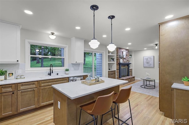 246 Leichester Cir, Ballwin, MO 63011 - kitchen featuring white cabinets, a kitchen island, tasteful backsplash, light wood-style flooring, and recessed lighting