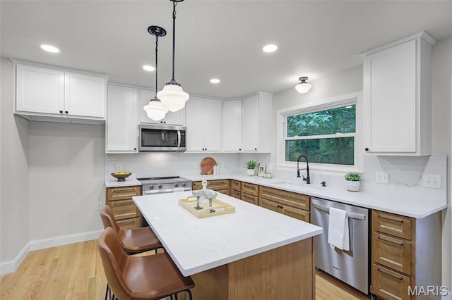 246 Leichester Cir, Ballwin, MO 63011 - kitchen featuring appliances with stainless steel finishes, tasteful backsplash, a kitchen bar, light wood-type flooring, and recessed lighting