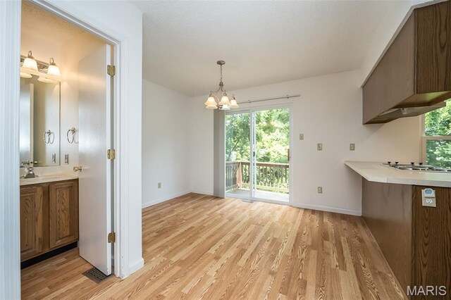 2266 Highland Hill Dr Unit F, Saint Peters, MO 63376 - unfurnished dining area with light wood finished floors, a chandelier, and healthy amount of natural light