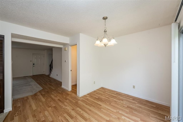 2266 Highland Hill Dr Unit F, Saint Peters, MO 63376 - spare room featuring a chandelier, light wood finished floors, stairs, and a textured ceiling