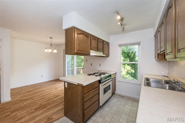 2266 Highland Hill Dr Unit F, Saint Peters, MO 63376 - kitchen with white gas range, light countertops, under cabinet range hood, a chandelier, and a textured ceiling