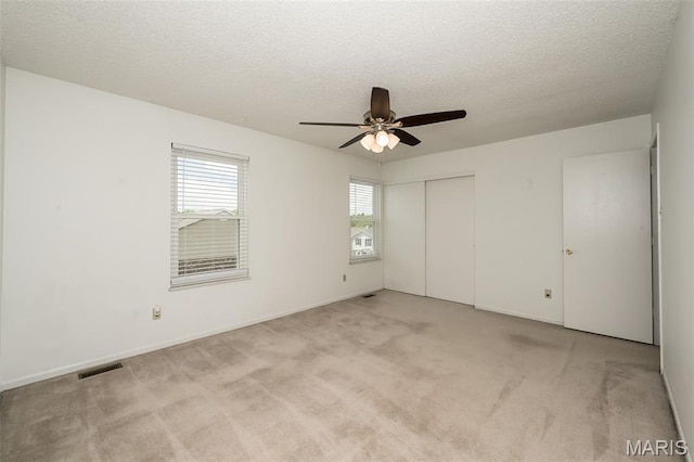2266 Highland Hill Dr Unit F, Saint Peters, MO 63376 - unfurnished bedroom featuring light colored carpet, a textured ceiling, a closet, and ceiling fan