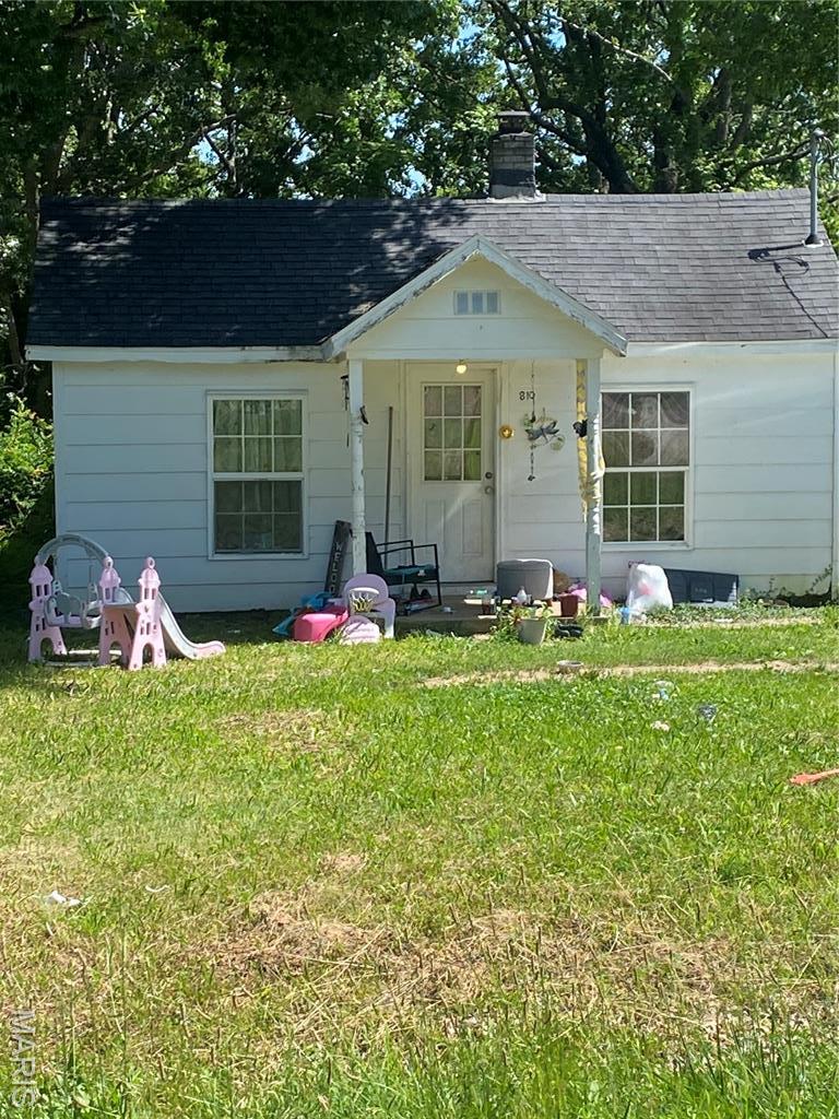 810 W Washington St, St James, MO 65559 - view of front of house featuring a chimney, a shingled roof, and a front lawn