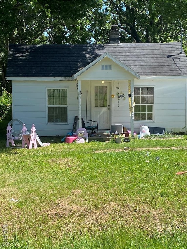 810 W Washington St, St James, MO 65559 - view of front of house featuring a chimney, a shingled roof, and a front lawn