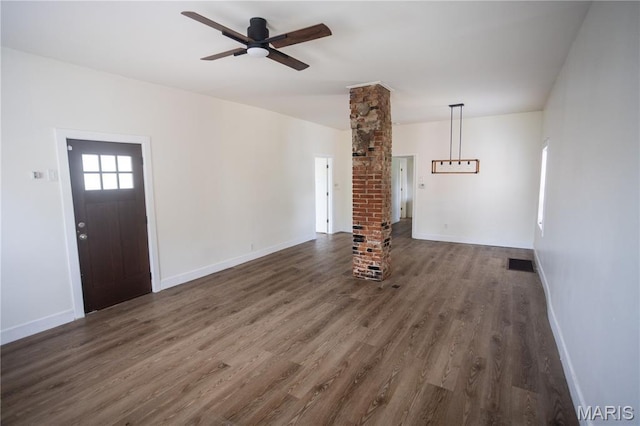 7353 Virginia Ave, Saint Louis, MO 63111 - unfurnished living room with ornate columns, dark wood-style flooring, and ceiling fan