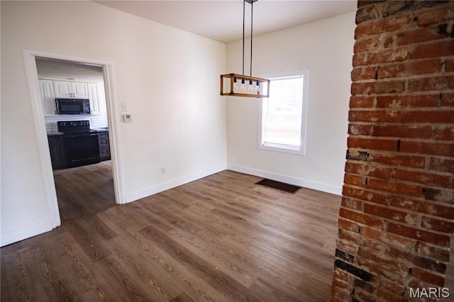 7353 Virginia Ave, Saint Louis, MO 63111 - unfurnished dining area with dark wood-type flooring and baseboards