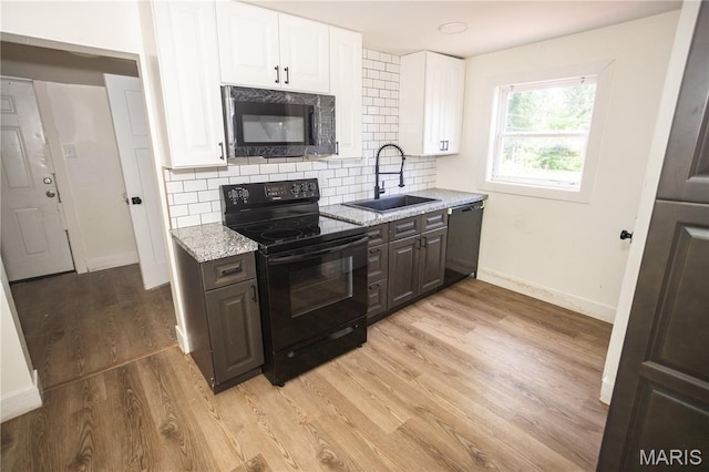 7353 Virginia Ave, Saint Louis, MO 63111 - kitchen with black appliances, white cabinets, decorative backsplash, light wood-style floors, and light stone countertops