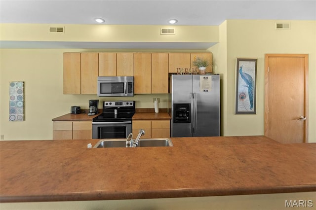 319 Timber Ridge Dr, Grafton, IL 62037 - kitchen with stainless steel appliances, light brown cabinetry, and recessed lighting