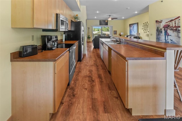 319 Timber Ridge Dr, Grafton, IL 62037 - kitchen featuring stainless steel appliances, dark wood-style floors, dark countertops, light brown cabinets, and a ceiling fan
