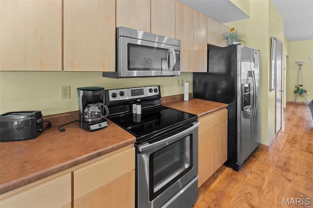 319 Timber Ridge Dr, Grafton, IL 62037 - kitchen with stainless steel appliances, light brown cabinetry, and light wood-style floors