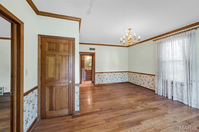 135 Oak Tree Dr, Webster Groves, MO 63119 - spare room featuring wainscoting, wood finished floors, wallpapered walls, ornamental molding, and a chandelier
