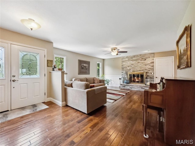 1171 Thunder Mountain Rd, Camdenton, MO 65020 - living room featuring ceiling fan, hardwood / wood-style floors, a stone fireplace, and wainscoting