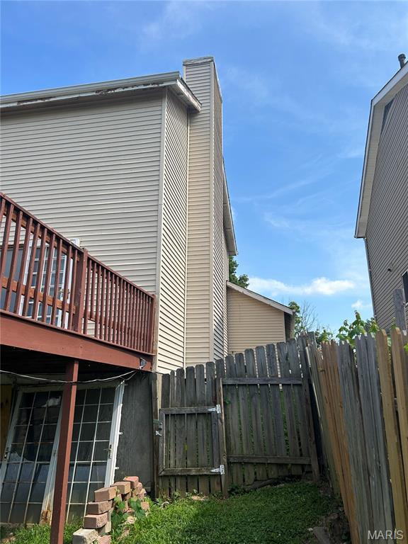 12922 High Crest St, Black Jack, MO 63033 - view of property exterior featuring a wooden deck and a chimney