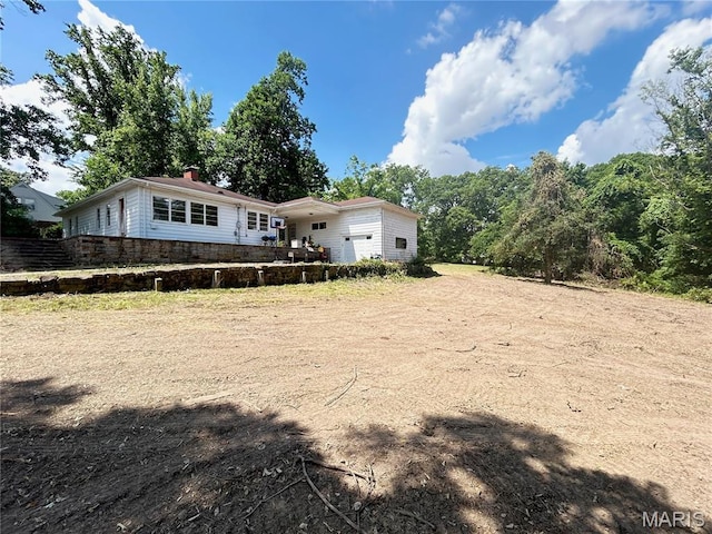 1203 N Main St, Salem, MO 65560 - rear view of house with a garage, dirt driveway, and a chimney